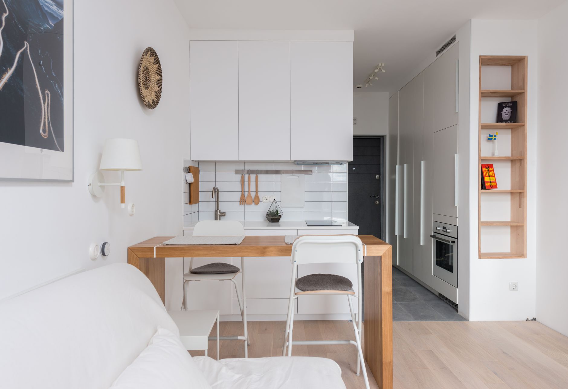 small apartment interior design cover showing a bright compact living room with layered storage, a slim sofa, and clean natural light