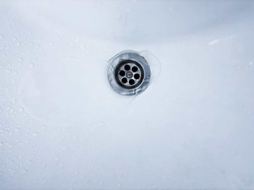 Drain cleaning tips cover illustration with a tidy kitchen sink, bathroom drain, laundry tray, and simple maintenance icons